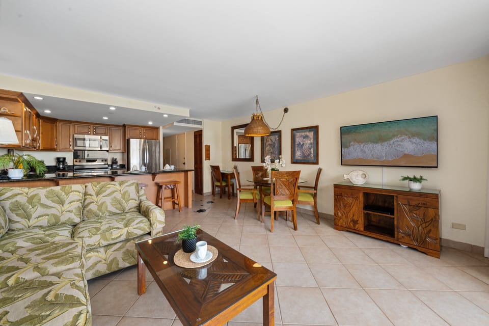 Bright open layout with living area, dining table, and full kitchen.