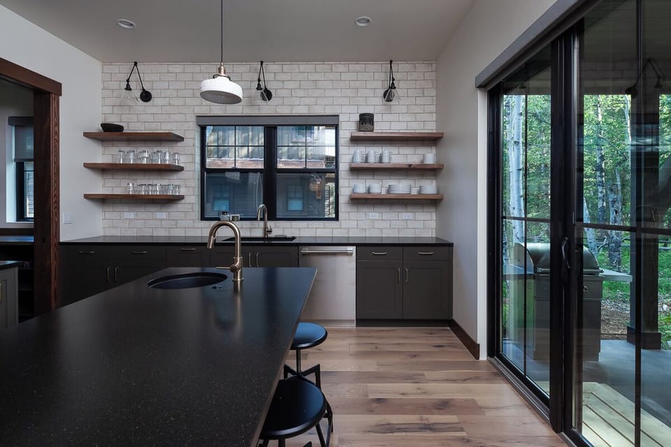 Brew coffee at the sleek sink with sunlit woodland backdrop.