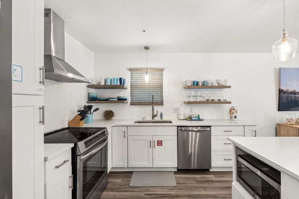 Stylish chef’s kitchen with quartz counters, large island, and modern coastal finishes.