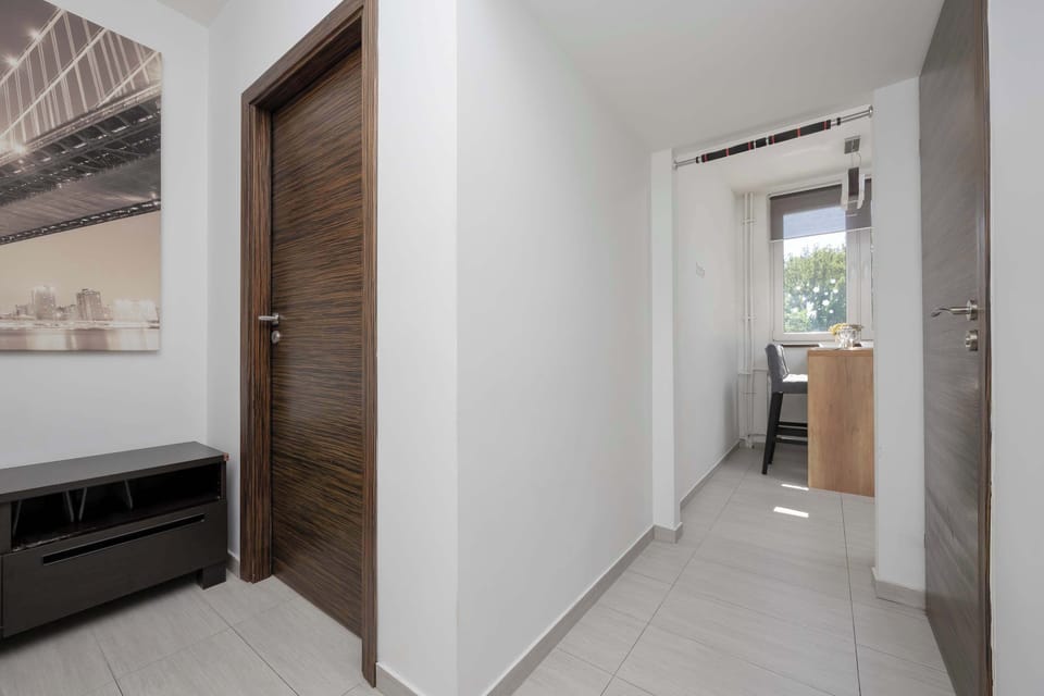 A view of the hallway leading toward the living area. White walls and wooden doors create a simple, modern look.