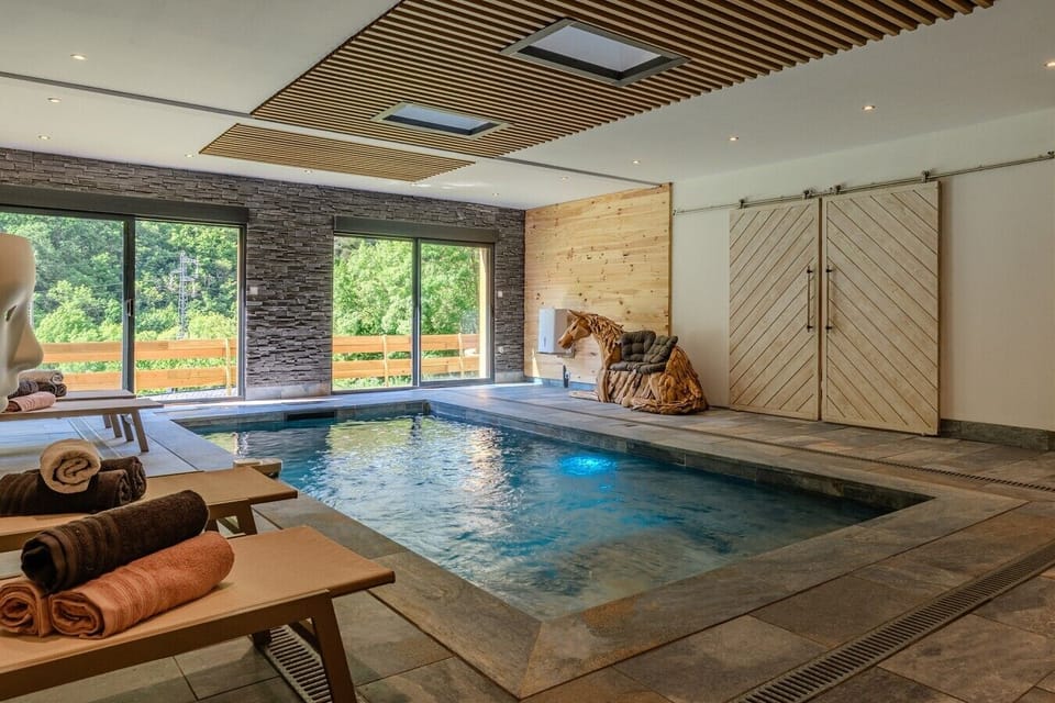 Détente au bord de la piscine intérieure, location prestige Pyrénées Orientales