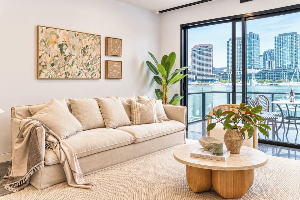 Bright waterfront living room with private balcony and skyline views