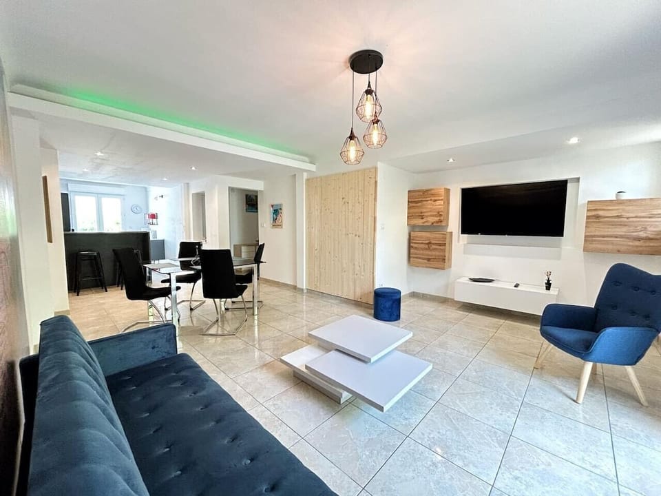 Spacious living room with flat-screen TV and blue sofa - Saint-Cyprien apartment