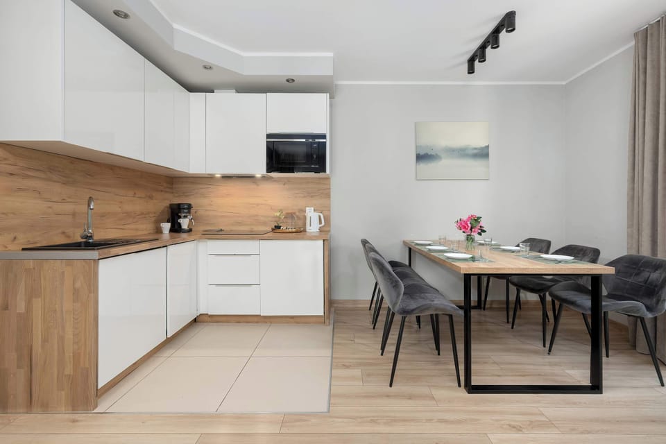 A modern kitchenette with wooden cabinets and a dining table. The bright interior is designed for comfortable everyday use.