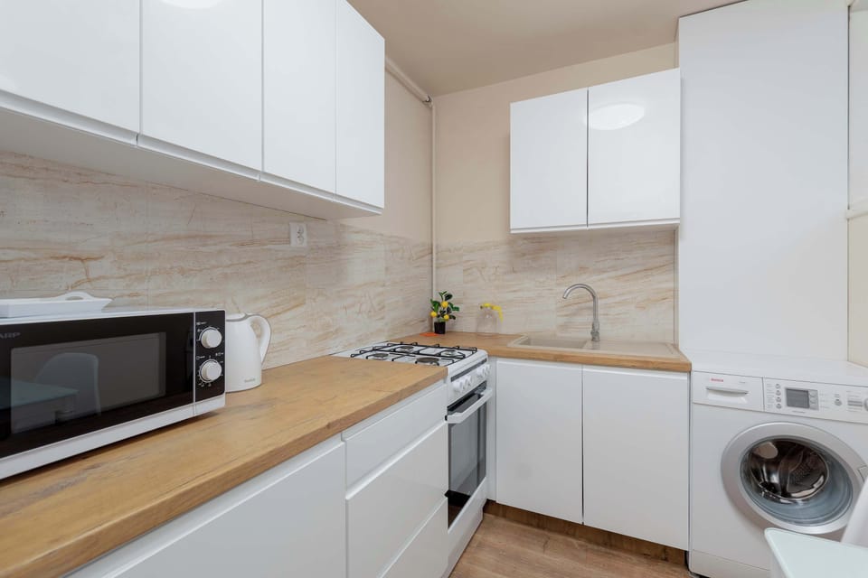 Fully equipped modern kitchen with microwave, washing machine, oven, induction hob and generous countertop space.