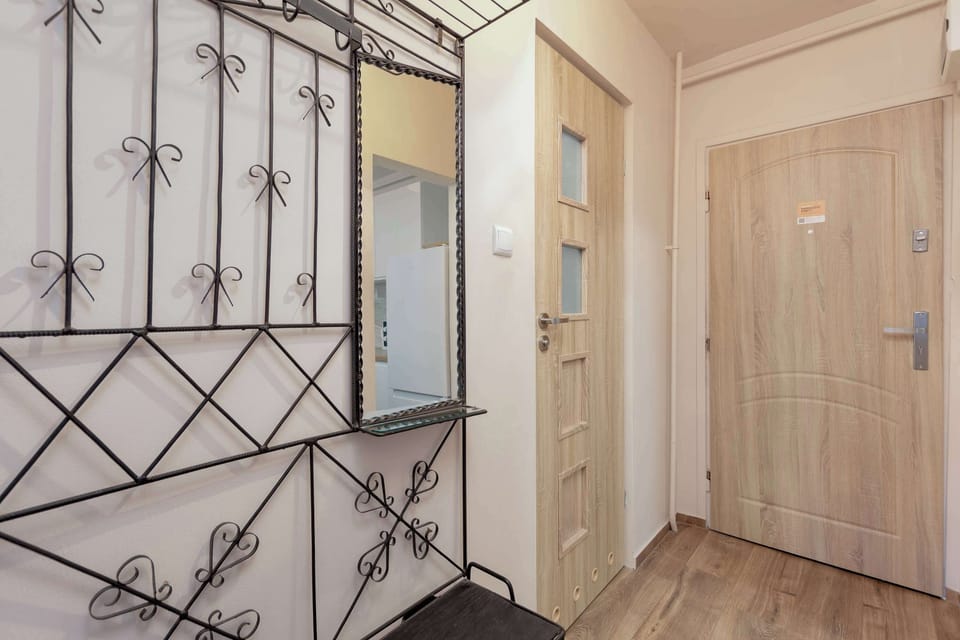 Entrance hallway with decorative wall panels, coat hooks and secure apartment entrance.