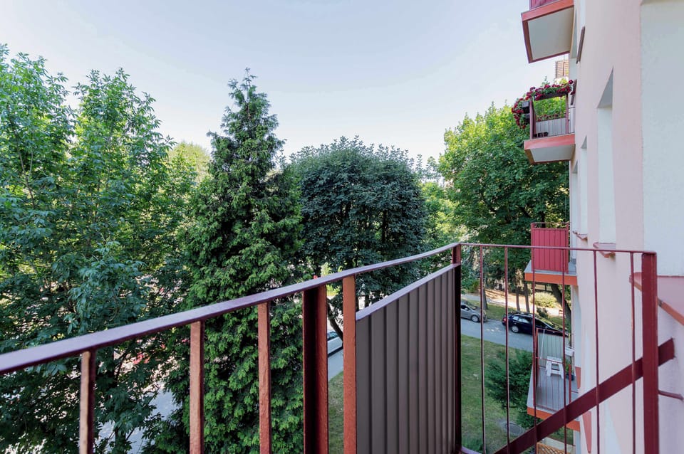 Private balcony overlooking greenery and a peaceful residential neighborhood.