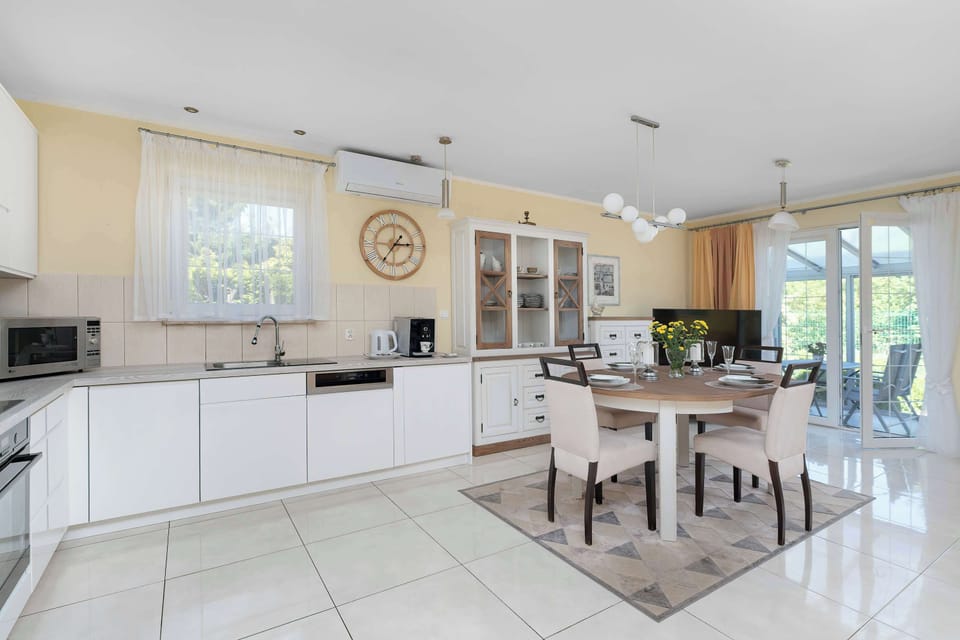 A spacious open-plan kitchen and dining area with abundant natural light. Modern finishes create a fresh appearance.