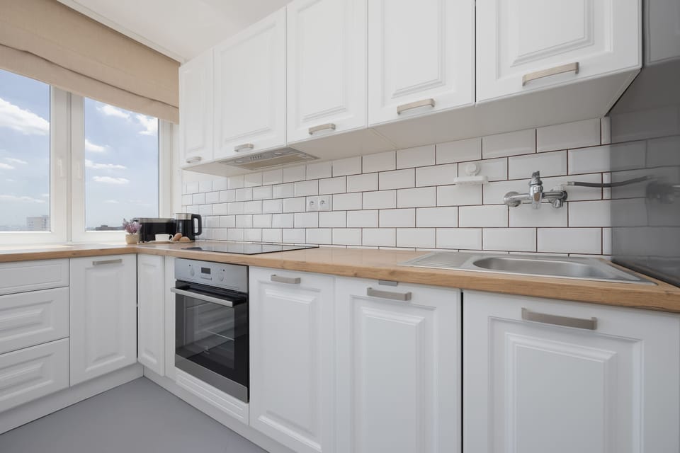 A stylish kitchen featuring white cabinetry and wooden countertops. The functional layout makes cooking both easy and enjoyable.