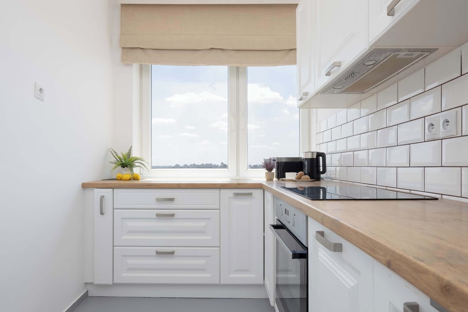 Another perspective of the bright kitchen with plenty of storage space. Large windows provide natural light while you prepare your meals.