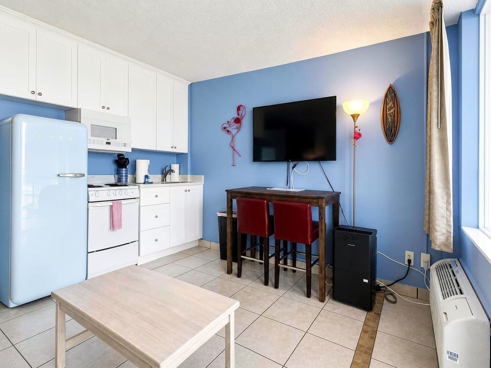 Your bright coastal retreat features a fully equipped kitchen with retro-style appliances, a cozy dining nook, and fun flamingo touches that set a beachy, playful tone.