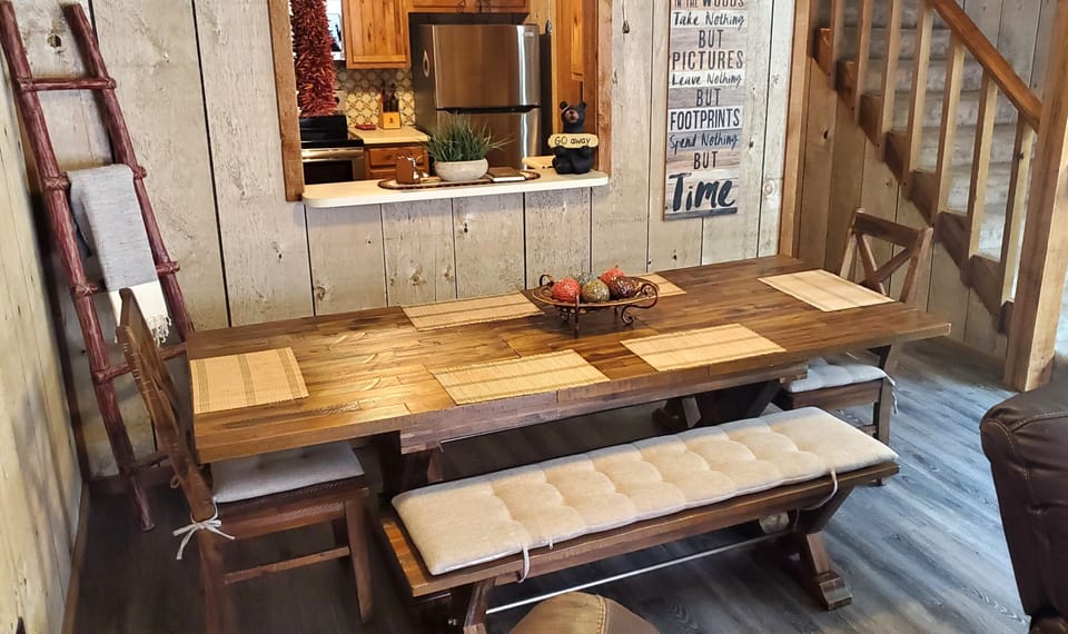 Gather around your rustic farmhouse-style dining table, perfectly positioned to enjoy the open kitchen. Sunlight streams in as you sip morning coffee, surrounded by warm wood tones and charming country decor.