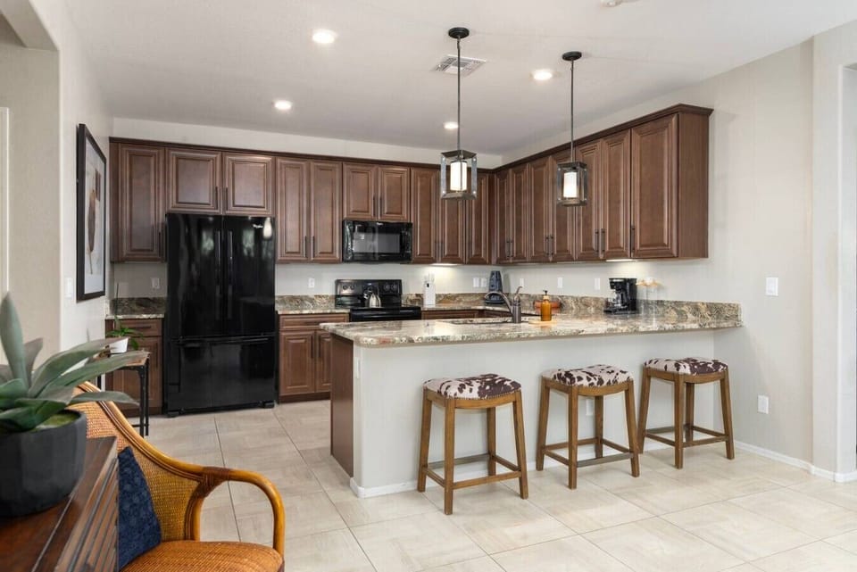 The fully equipped kitchen features granite countertops, stainless steel appliances, and plenty of space to prepare everything from a quick breakfast to family dinners.