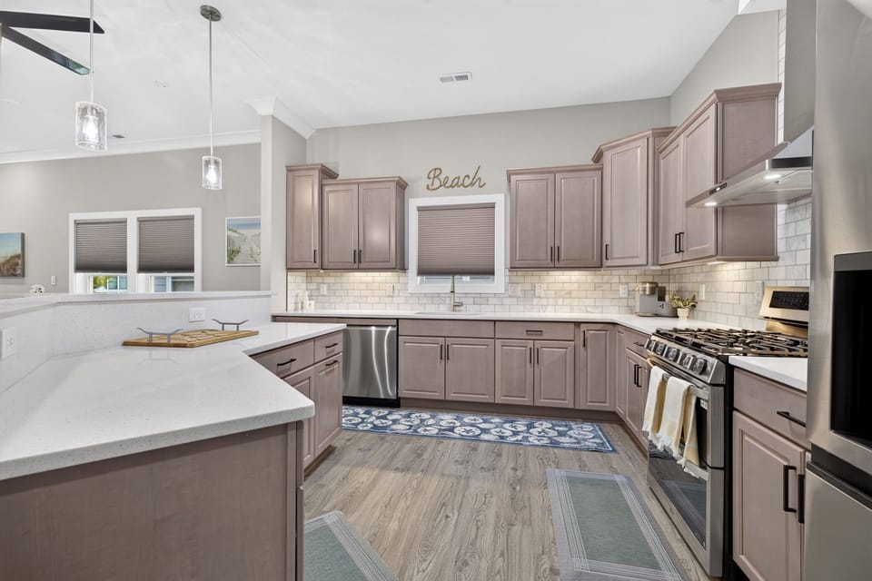 Fully equipped kitchen with ample counter space, modern appliances, and seating for the whole group.