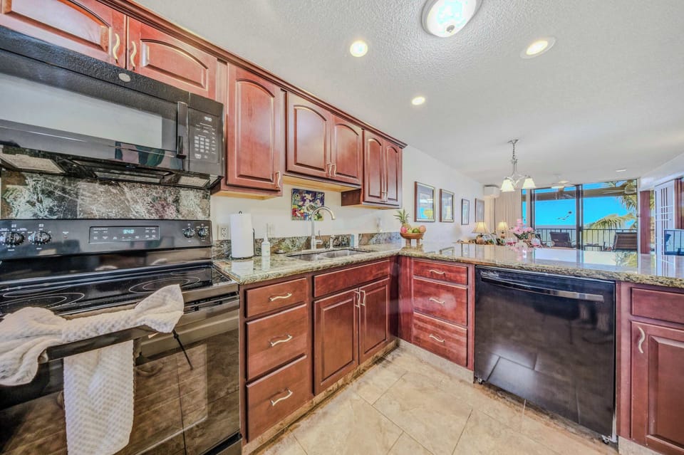 Spacious kitchen layout featuring wooden cabinetry, full appliances, and ample counter space. 🍳
