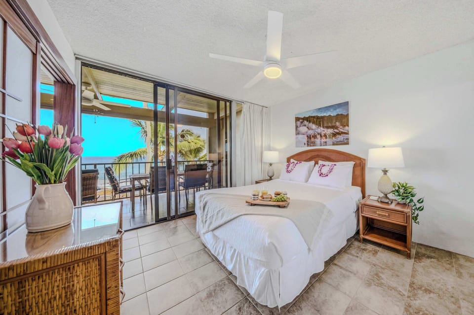 Bright bedroom layout featuring a comfortable bed, ceiling fan, and direct balcony access. 🛏️