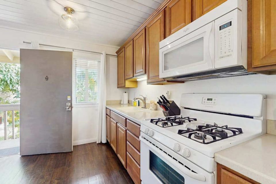 Bright Kitchen Layout with Gas Range, Overhead Microwave & Entry Access
