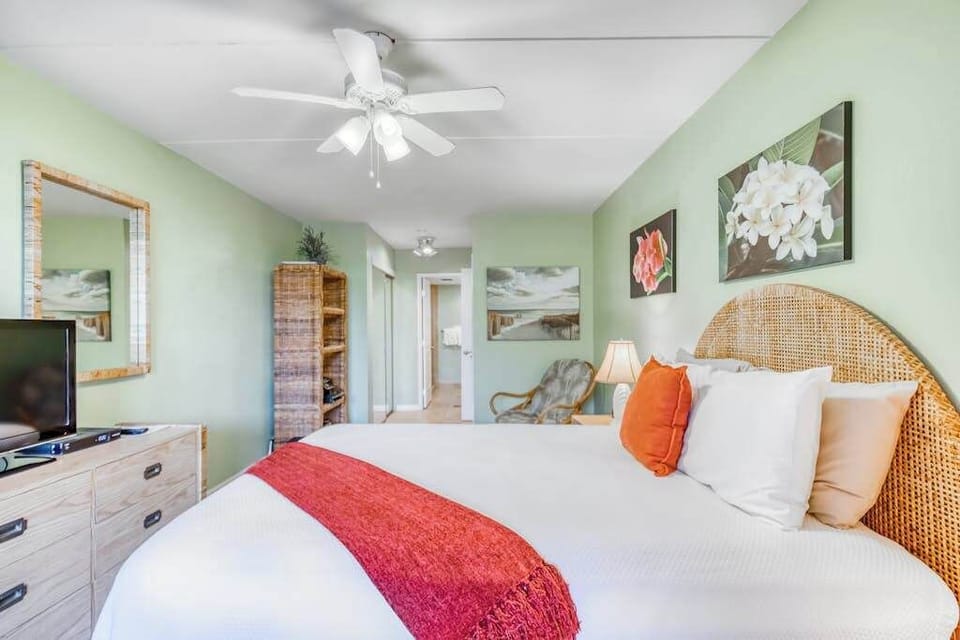 Fully furnished bedroom featuring a cozy bed setup, overhead ceiling fan, spacious storage dresser, and a large vanity wall mirror! 🛏️✨