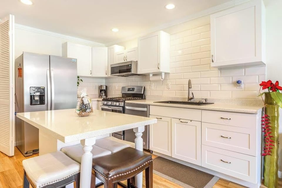 Fully Equipped Modern Kitchen with Island Stools and Stainless Steel Appliances