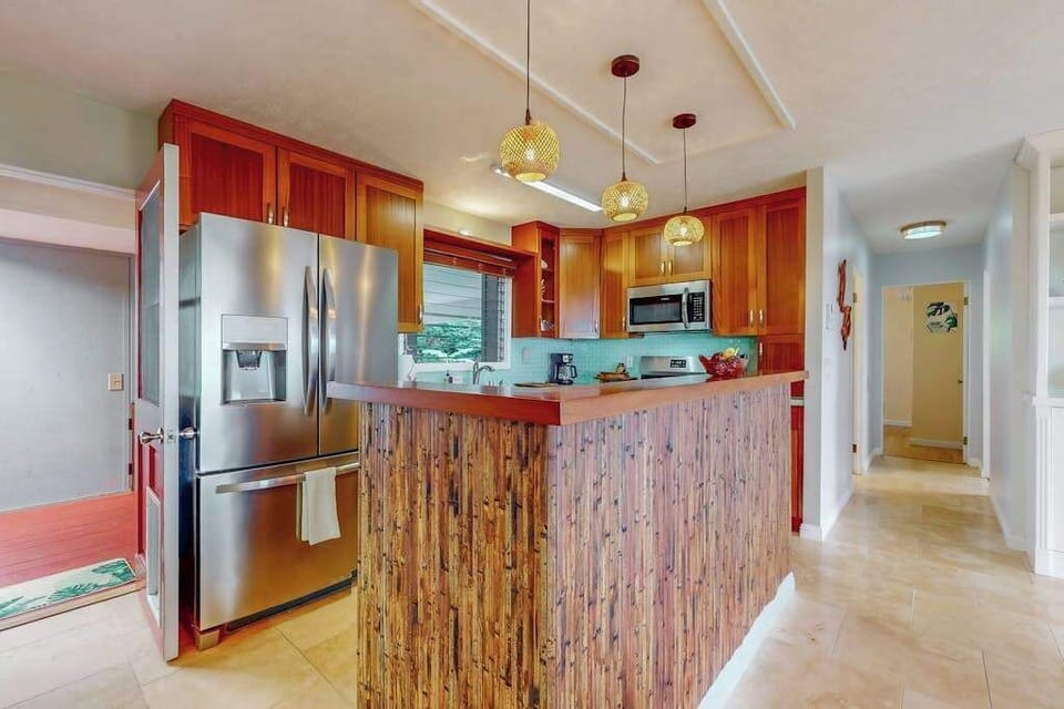 Kitchen island anchors bright cooking space with stainless appliances nearby