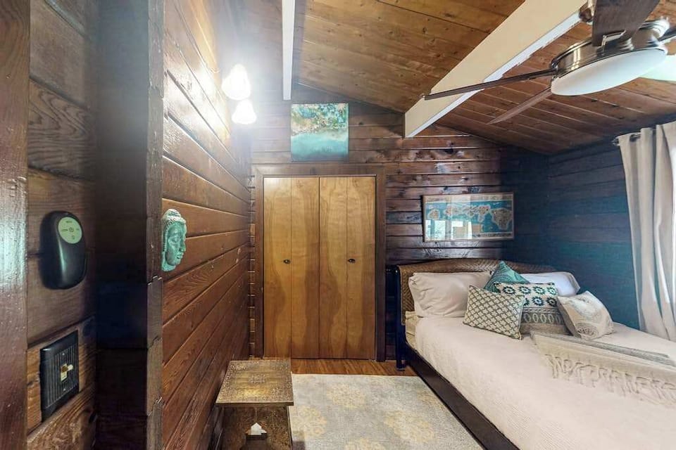 King bedroom with ceiling fan and flat screen tv.