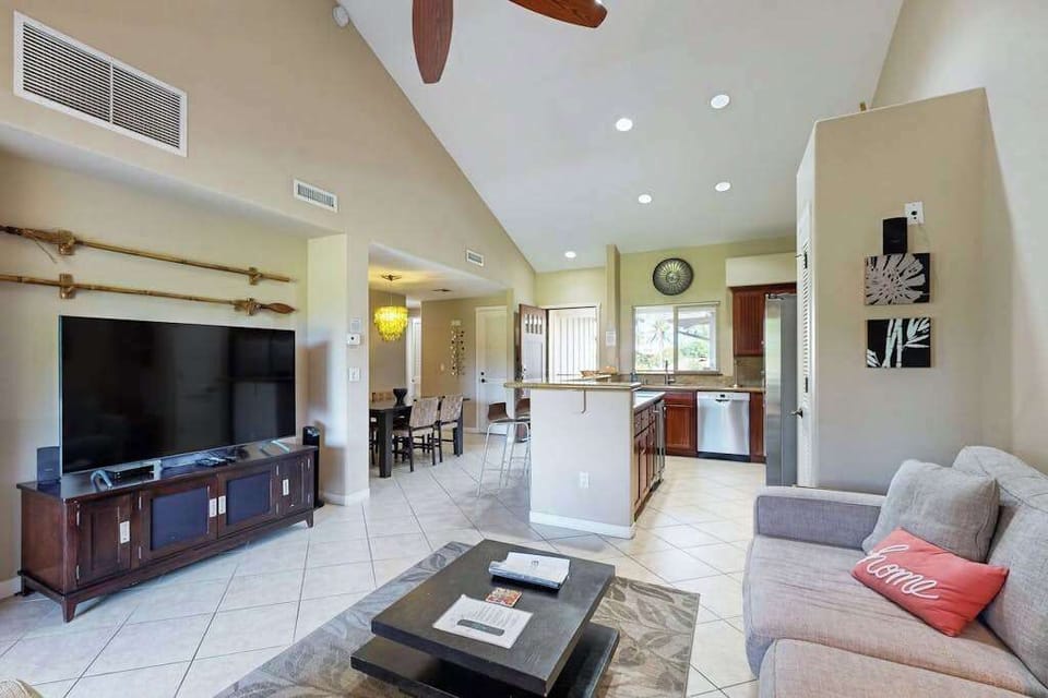 Living room with vaulted ceilings with a large flat screen tv and open concept to design. 