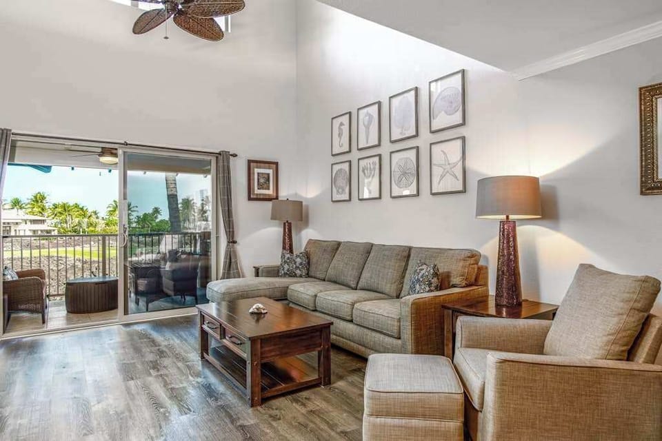 Living room filled with streaming light entering from the glass doors of the lanai.