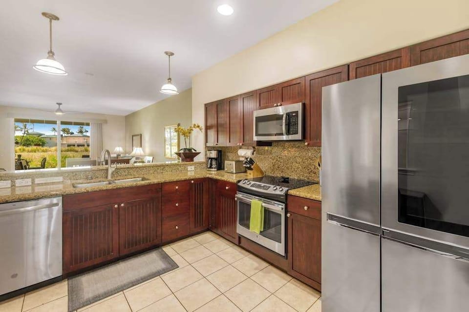 Large open air kitchen with new stainless steel appliances.