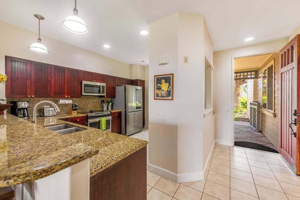 Large open air kitchen with new stainless steel appliances.