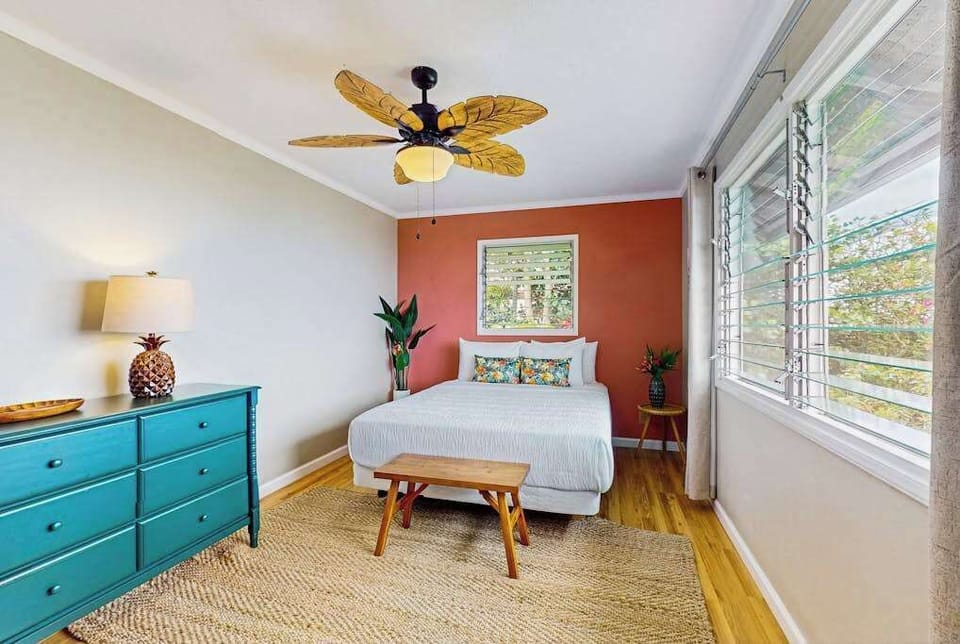 Bedroom offers queen bed dresser ceiling fan and garden views