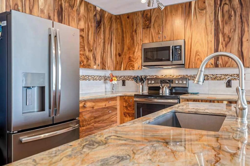 Chef's Kitchen Highlights Rich Natural Wood Cabinets & Polished Stone Countertops