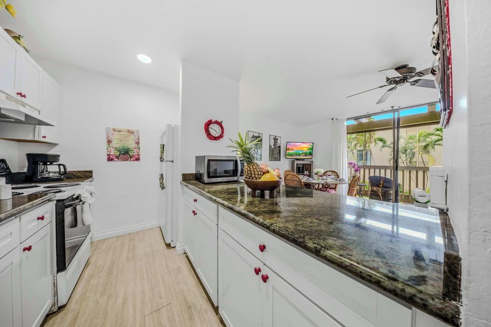 Spacious galley kitchen featuring extensive dark countertops and modern white cabinetry. 🍳✨