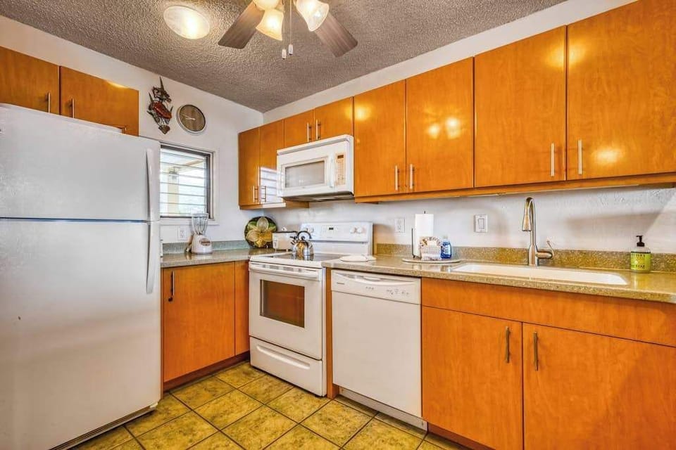 Fully functional kitchen featuring a refrigerator, stove, microwave, dishwasher, and plenty of cabinet storage