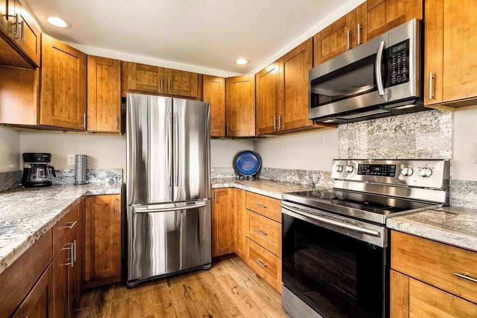 Modern stainless steel appliances including a spacious double-door refrigerator and stove setup