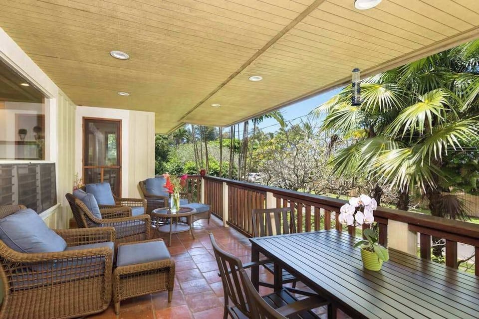 Covered patio offers comfortable furnishings, garden views, and breezy relaxation
