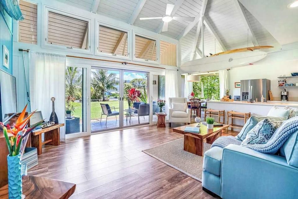 Open-concept living room with vaulted ceilings and lanai access.