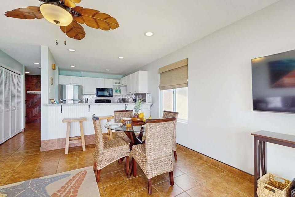 Dining room with seating for four and extra seating at the barstools at the kitchen counter.