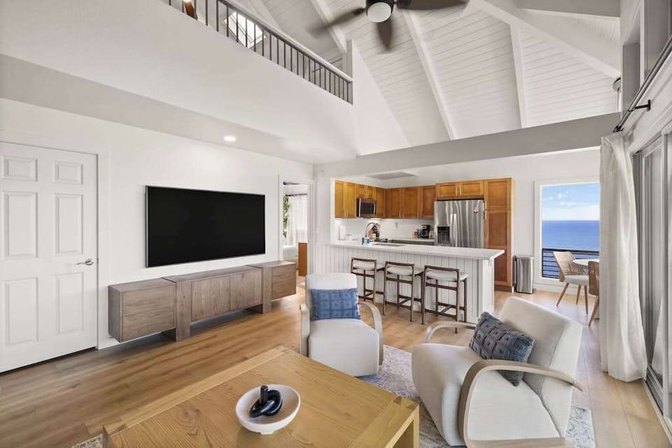 Bright living room with ocean views and a large TV