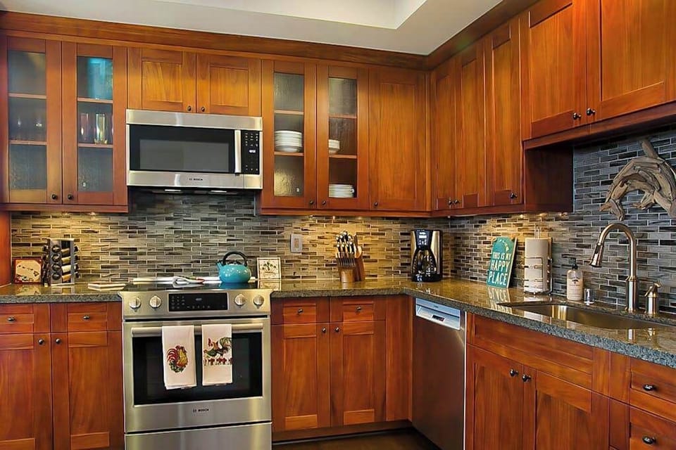 High-end and high-style, the open kitchen boasts handsome cherry cabinets, granite counters, stainless appliances, and a large island with seating for three. 