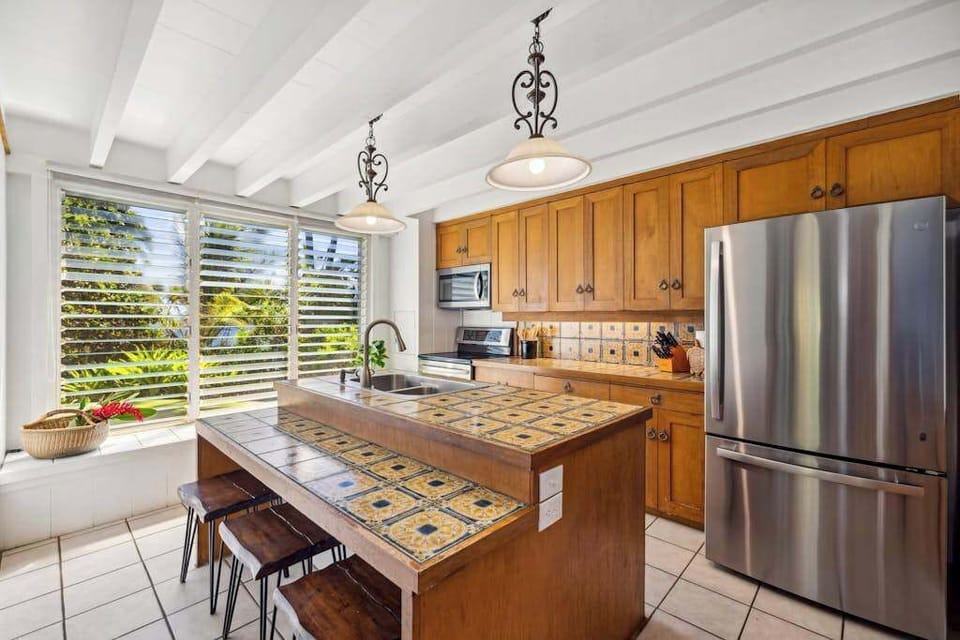 Newly remodeled stainless steel kitchen with island and barstools for extra seating. 