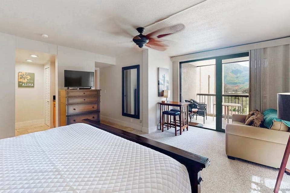 Studio features king bed, ceiling fan, and scenic balcony views