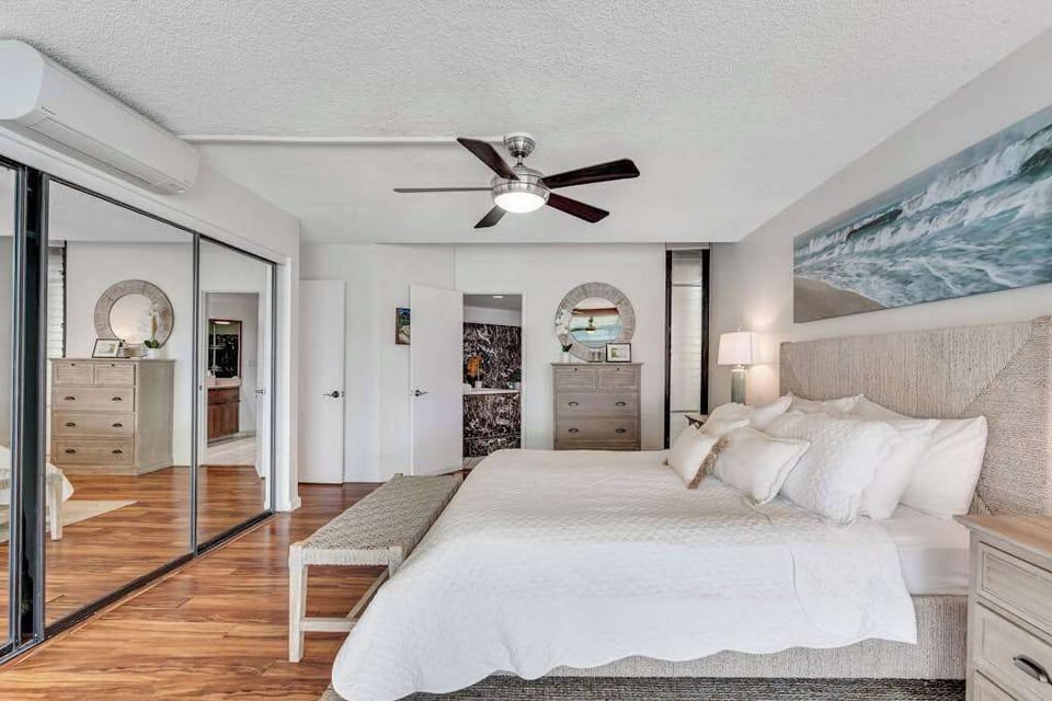 Primary bedroom with mirrored closets, spacious and full of natural light