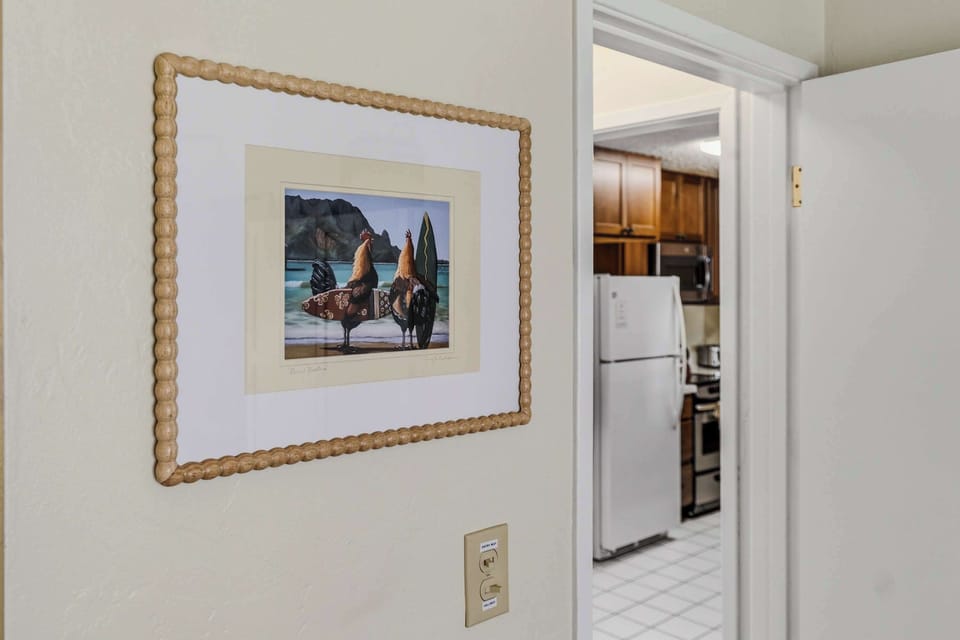 Hallway wall artwork with view looking into the kitchen