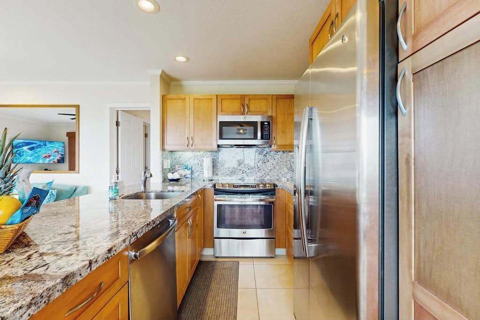 Bright kitchen showcases white cabinetry, stainless appliances, and organized counters