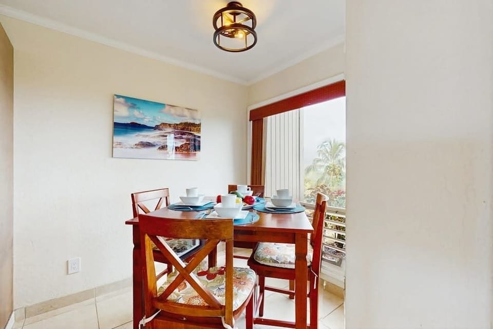 Dining room presents a round table, chairs, and garden views