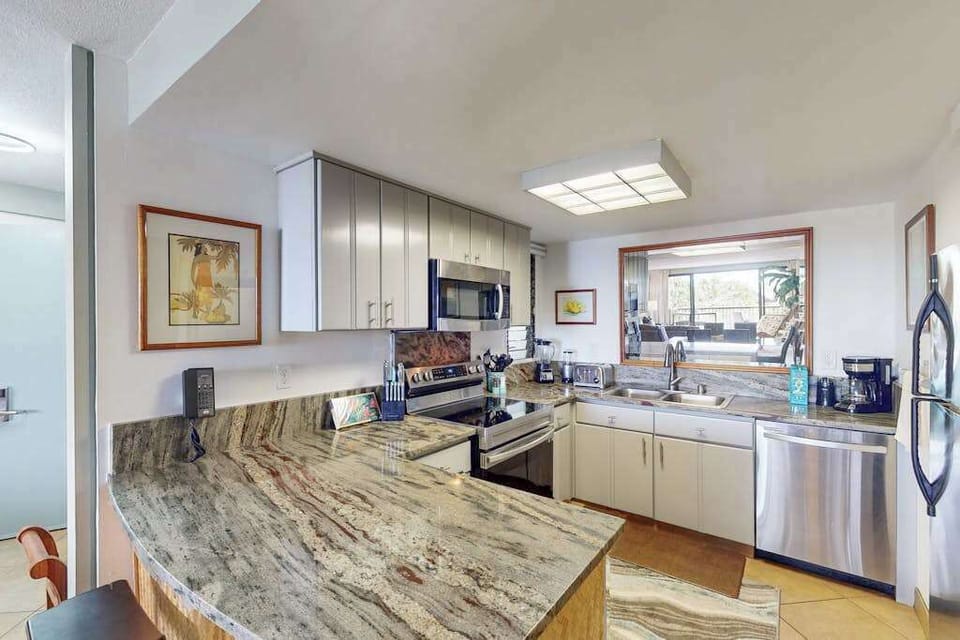 Granite kitchen gleams with modern appliances and generous preparation space
