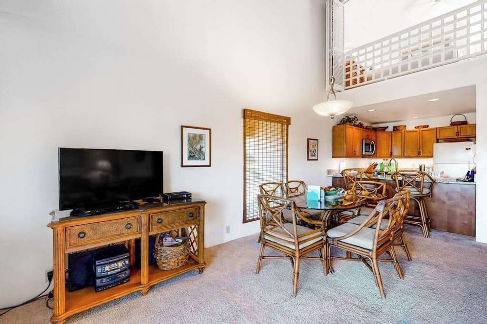 Open living room connects dining kitchen television for relaxing stays