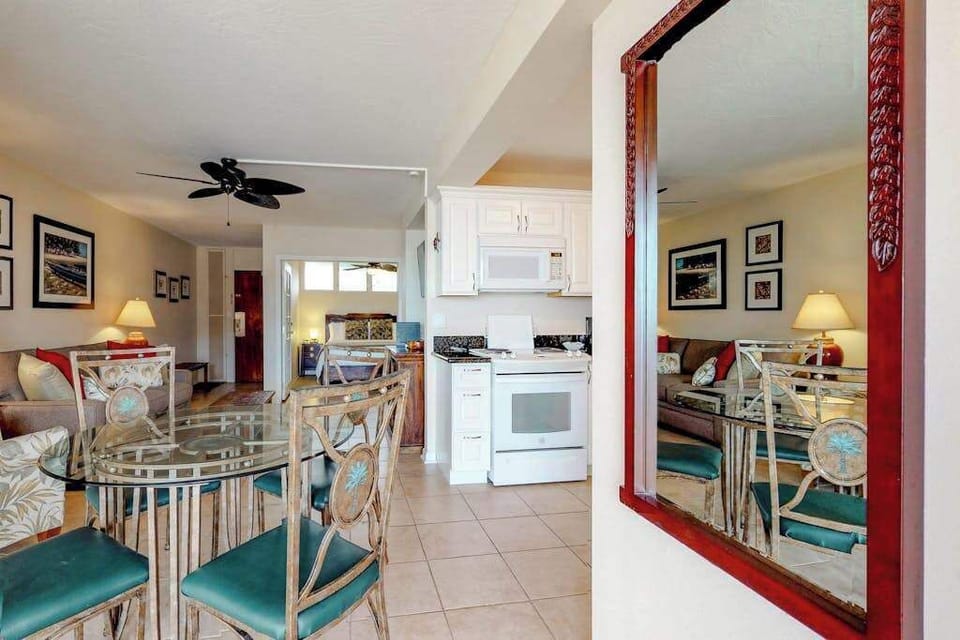 Dining area featuring a red-framed mirror and teal dining chairs
