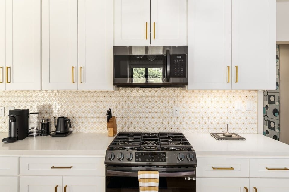 Six-burner gas range with geometric backsplash and sleek black stainless finishes