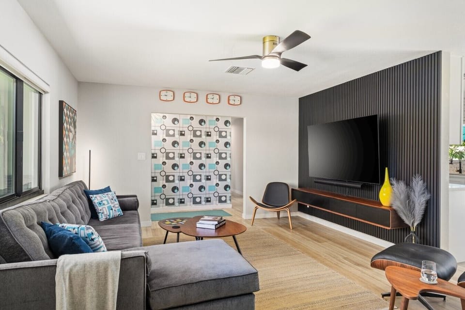 Stylish living room with a 75-inch smart TV, cozy sectional, and playful desert decor.